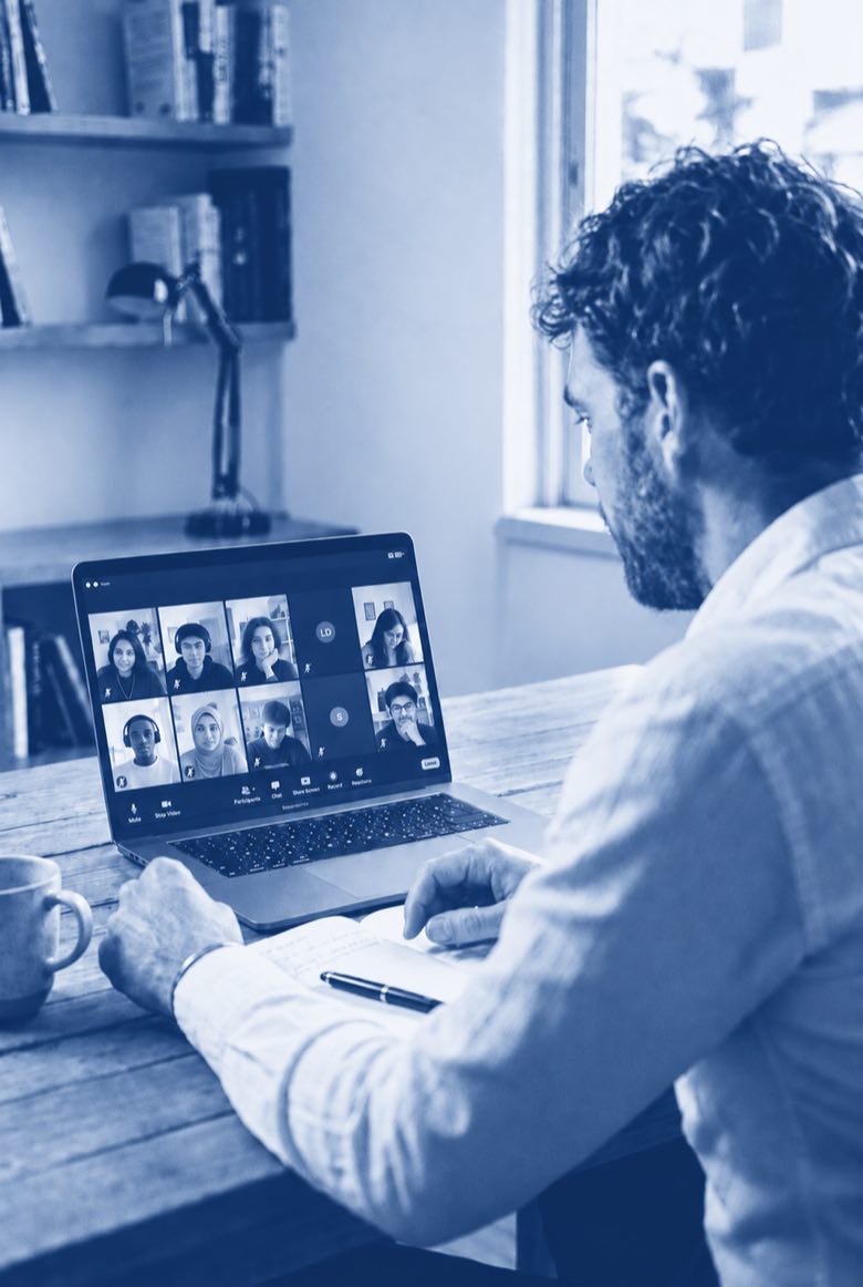 Illustration einer live moderierten Online-Session: Blick &uuml;ber die Schulter auf einen Laptop mit der Galerieansicht der Teilnehmenden.